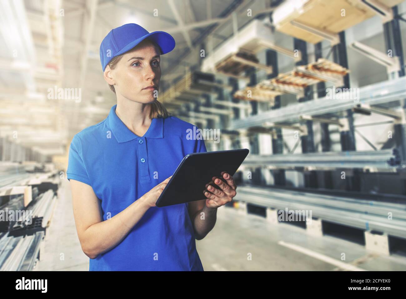 gestione delle scorte - giovane dipendente di magazzino con tablet digitale al deposito di materiale di costruzione Foto Stock