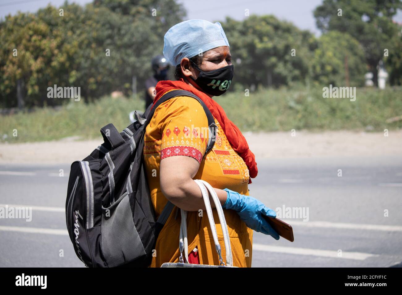 Dehradun, Uttarakhand/India - 06 2020 settembre: Una donna che indossa maschera facciale, copri-testa e guanti in mano. Foto Stock