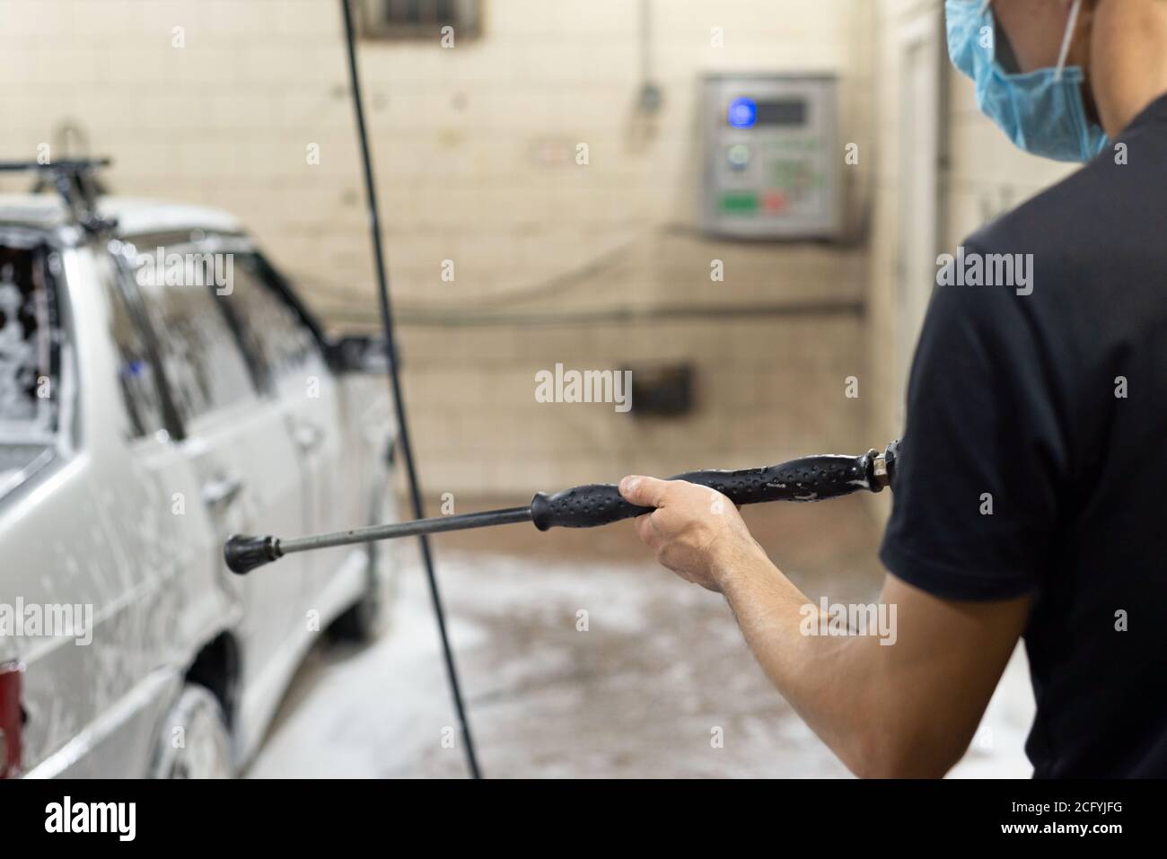 coronavirus pulizia della macchina, lavando la carrozzeria con un pulitore da soluzione di sapone. Il lavoro di tecnici automatici durante il periodo di quarantena COV Foto Stock