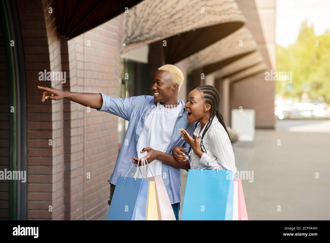 Incredibile vendere fuori. Scioccato afroamericano ragazzo e ragazza guarda in vetrina Foto Stock