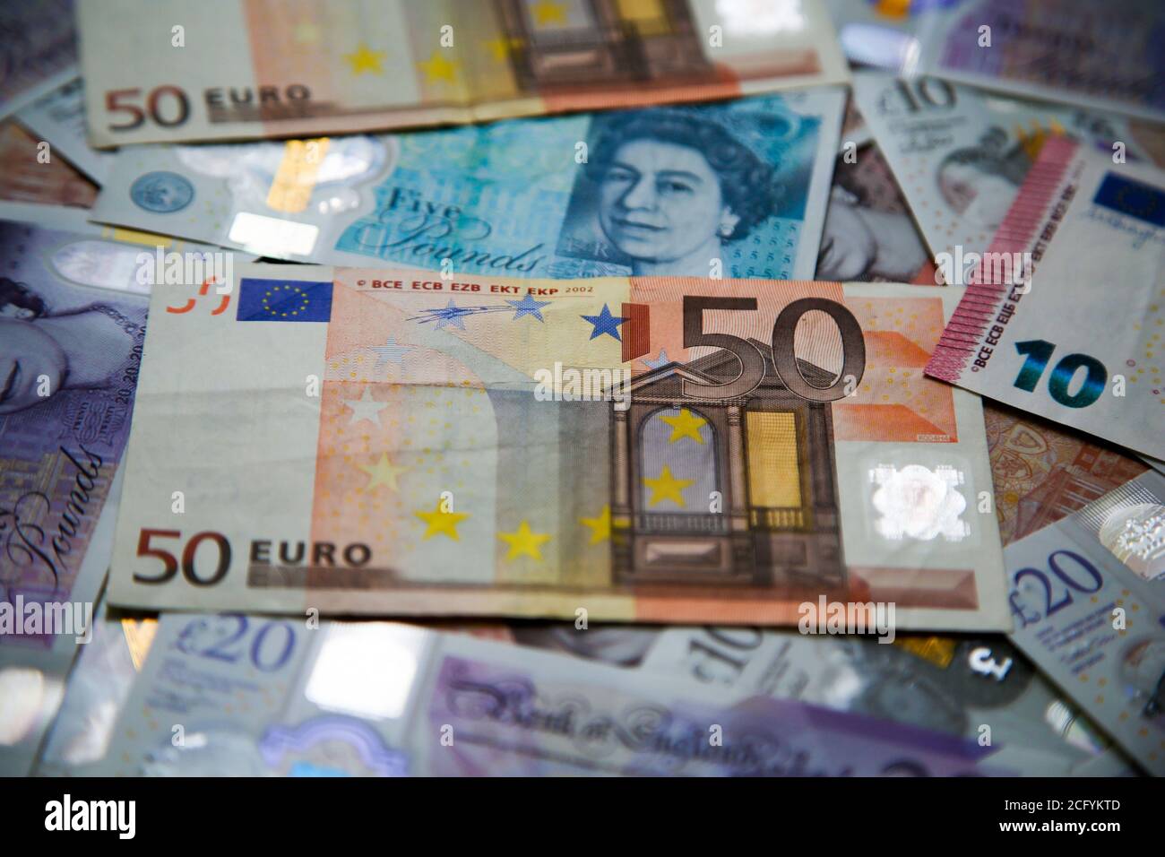 In questa illustrazione fotografica, una collezione di banconote inglesi da cinque, dieci e venti sterline e dieci e cinquanta euro è visibile. Foto Stock