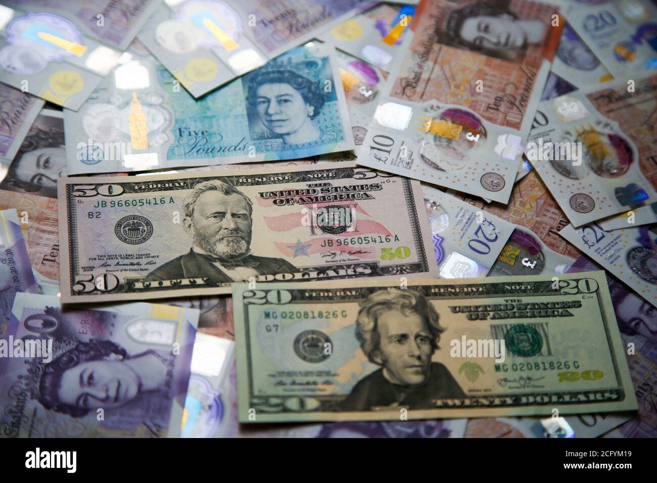In questa illustrazione fotografica, una collezione di cinque, dieci e venti libbre britanniche sterline e venti e cinquanta dollari statunitensi banconote sono visualizzate. Foto Stock