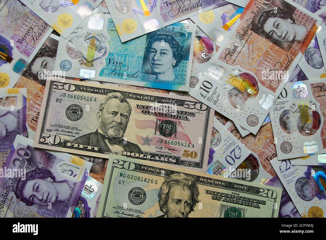 In questa illustrazione fotografica, una collezione di cinque, dieci e venti libbre britanniche sterline e venti e cinquanta dollari statunitensi banconote sono visualizzate. Foto Stock