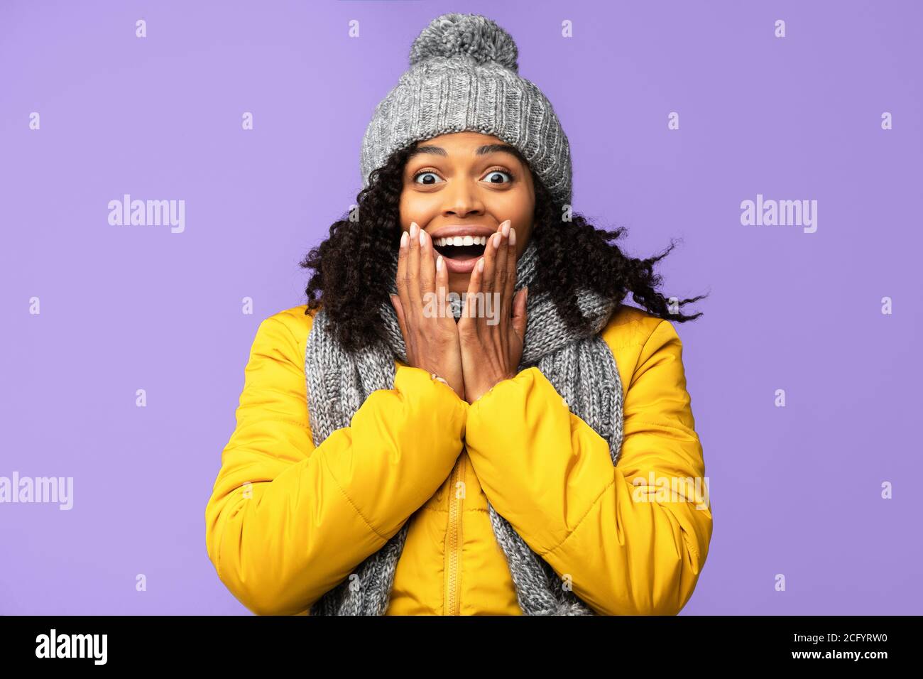 Ragazza africana eccitata in abiti invernali gridando OMG, Studio Shot Foto Stock