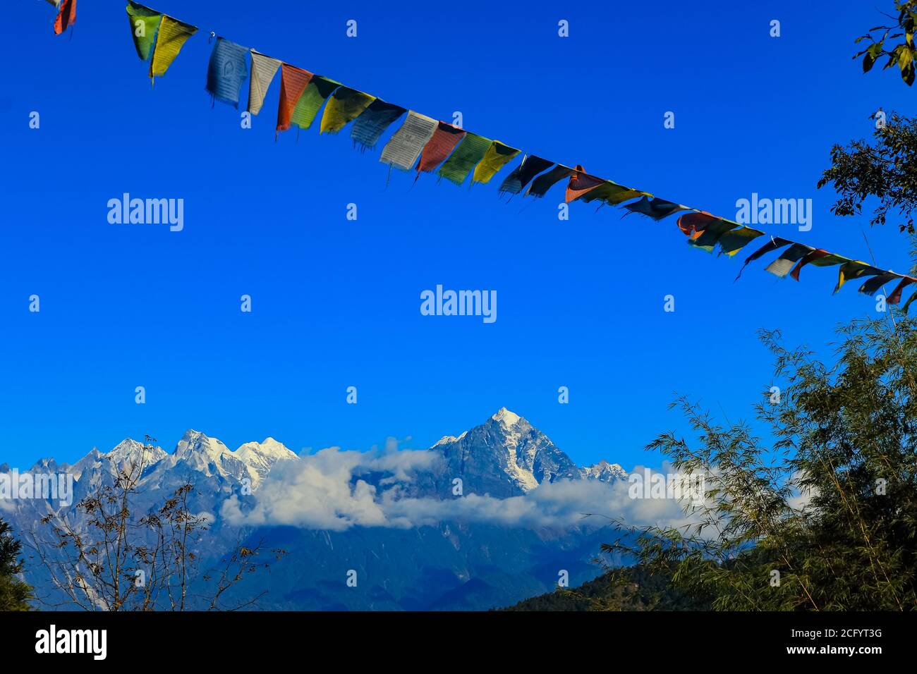 Colorata bandiera tibetana di preghiera con montagne ricoperte di neve nel Sfondo bellissimo con il paesaggio in Sikkim India Foto Stock