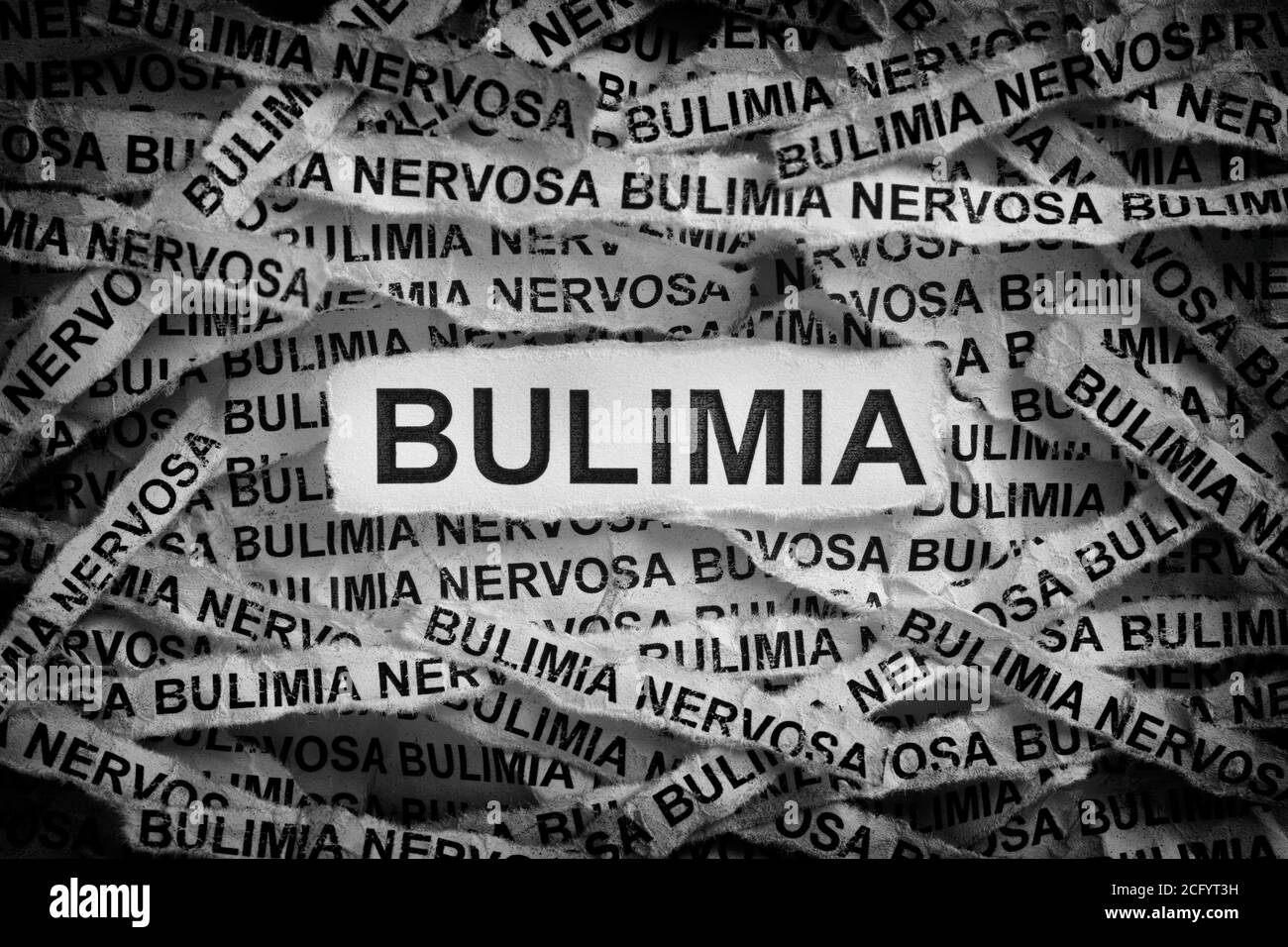 Bulimia. Strappato pezzi di carta con la parola Bulimia. Immagine concettuale. Bianco e nero. Primo piano. Foto Stock
