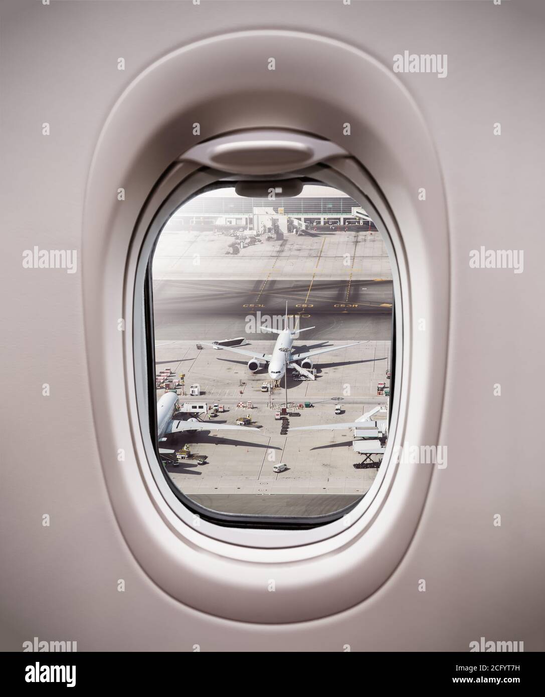 Vista dalla finestra dell'aereo al terminal con aeroplani parcheggiati. Concetto di viaggio moderno e veloce Foto Stock