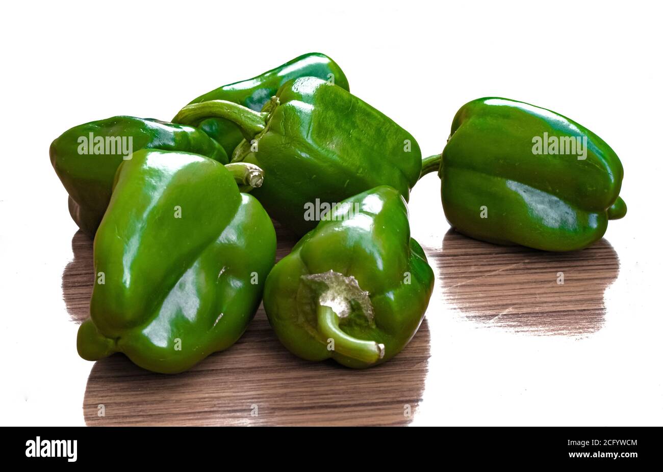 Gruppo di capsicums e la loro tessitura di legno d'ombra isolato su bianco. Foto Stock