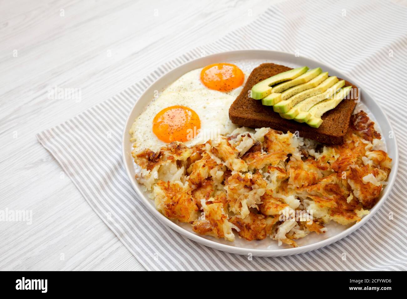 Gustosi Hashbrown fritti fatti in casa e uova su un piatto, vista laterale. Spazio di copia. Foto Stock