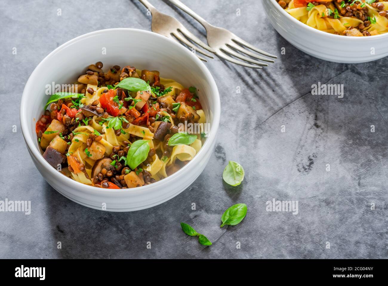 Lenticchie e melanzane ragu con tagliatelle e basilico fresco - cibo vegetariano sano Foto Stock