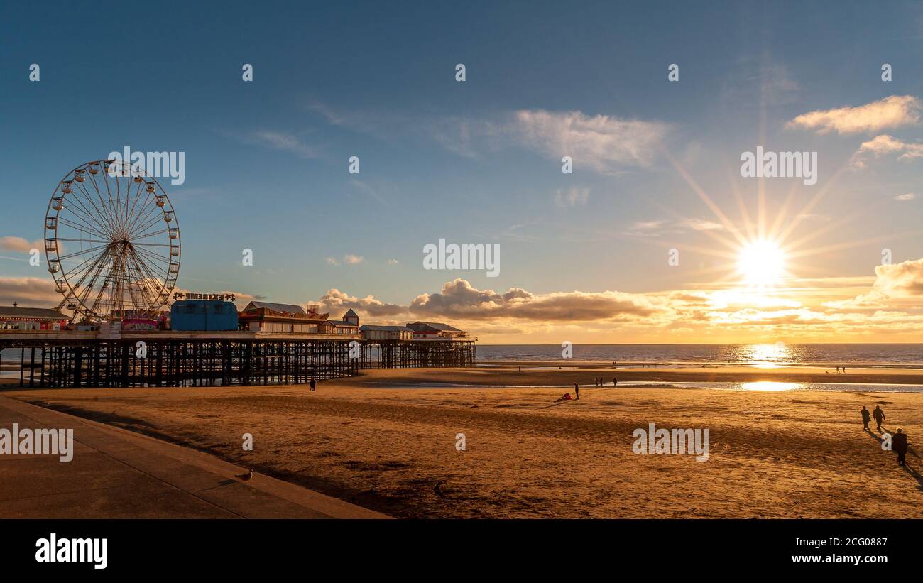 Una vista dalla spiaggia di Golden Mile di Blackpool con il molo centrale e la ruota panoramica, presa al tramonto Foto Stock