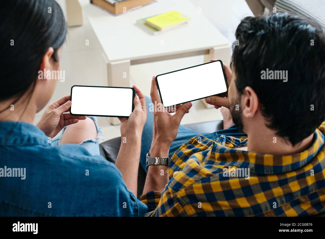 Young Couple Holding Phone con schermo bianco per Copy Space Foto Stock