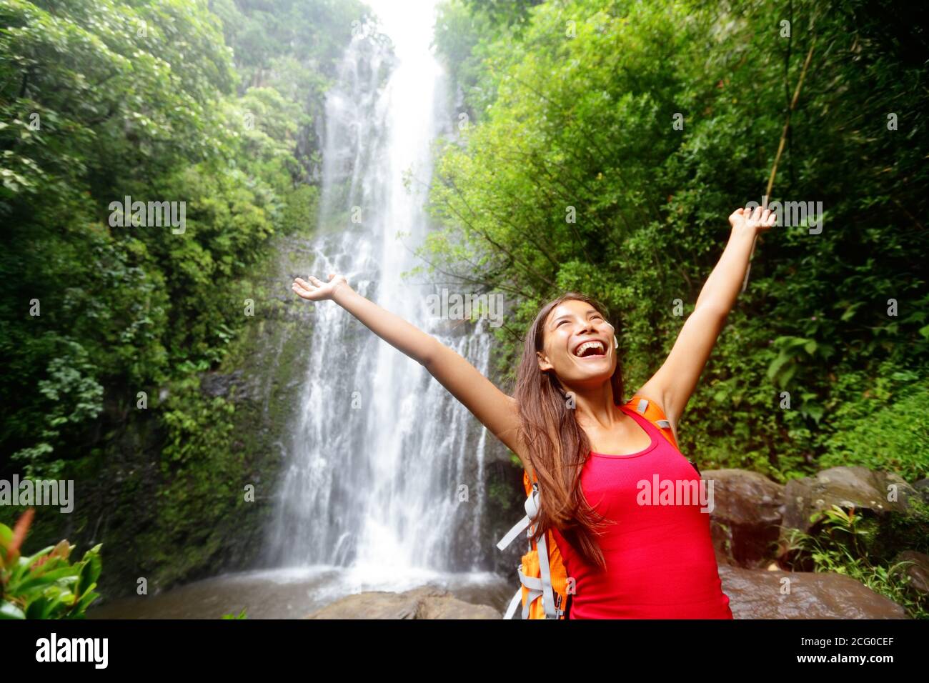 Donna delle Hawaii eccitata dalla cascata Foto Stock