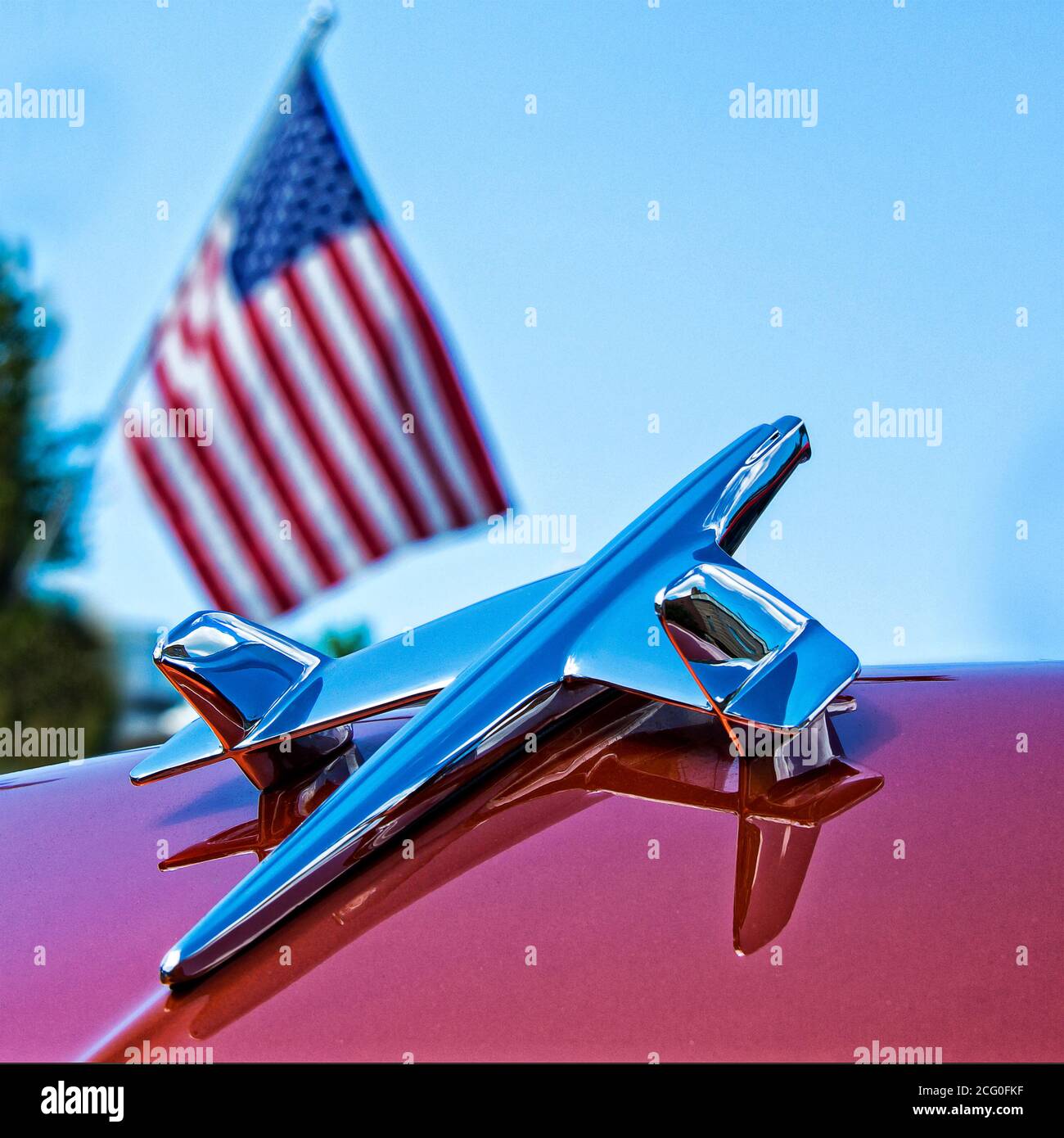 Emblema di aeroplano a doppia ala Chevrolet (anni '50) con bandiera su un'auto con cofano sollevato Foto Stock
