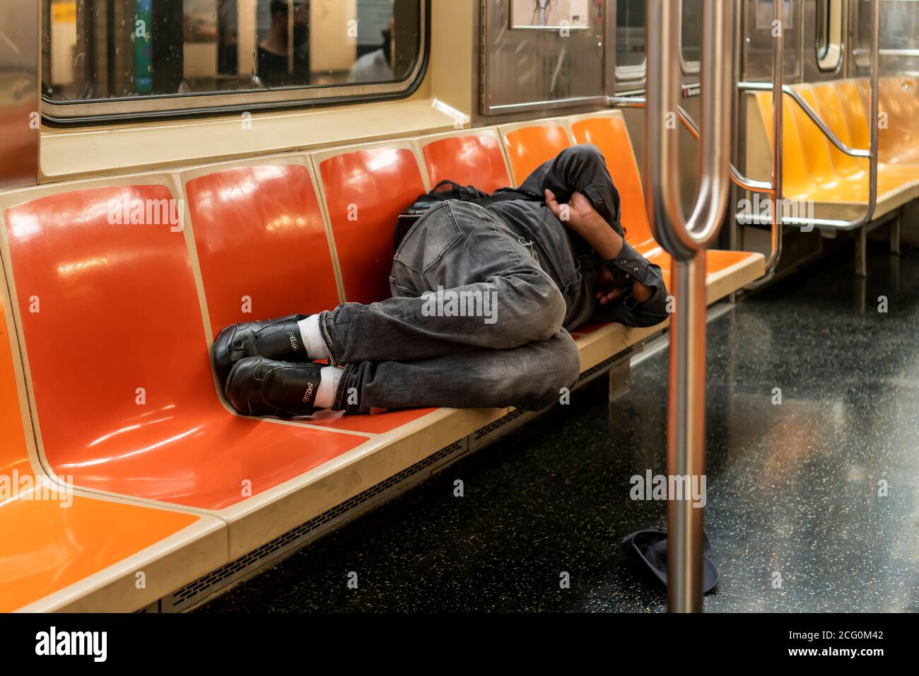 Un uomo senza dimora dorme su un treno metropolitano a New York domenica 30 agosto 2020. (© Richard B. Levine) Foto Stock
