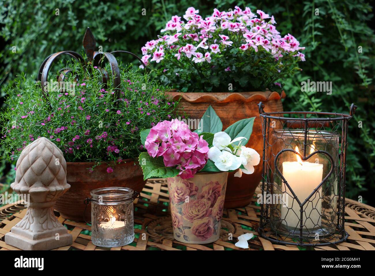 decorazione giardino con fiori e candele rosa estate Foto Stock