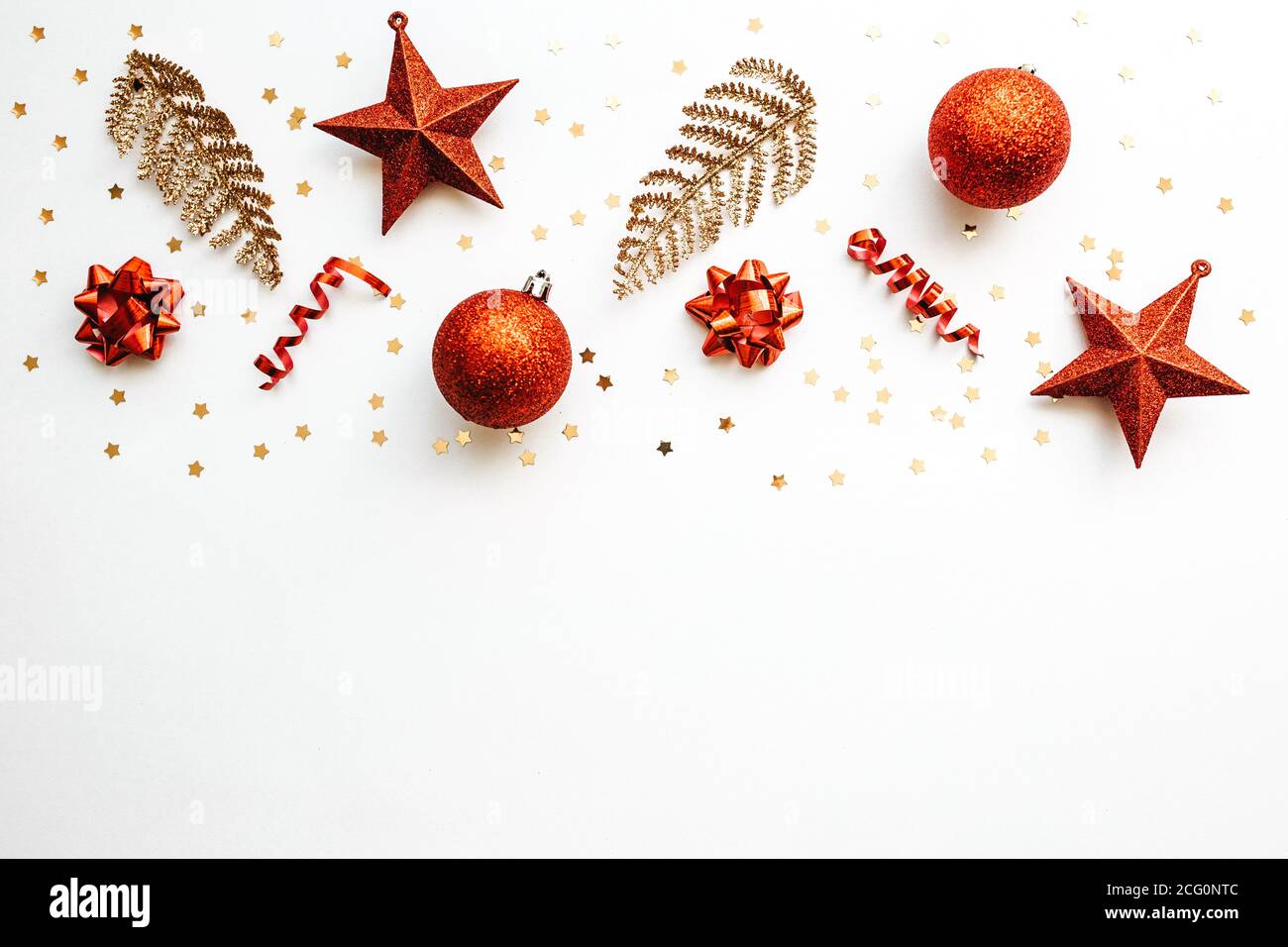 Oggetti di Natale in oro e rosso su sfondo bianco. Sfondo concettuale di Natale o Capodanno. In basso c'è spazio vuoto per il testo. Foto Stock