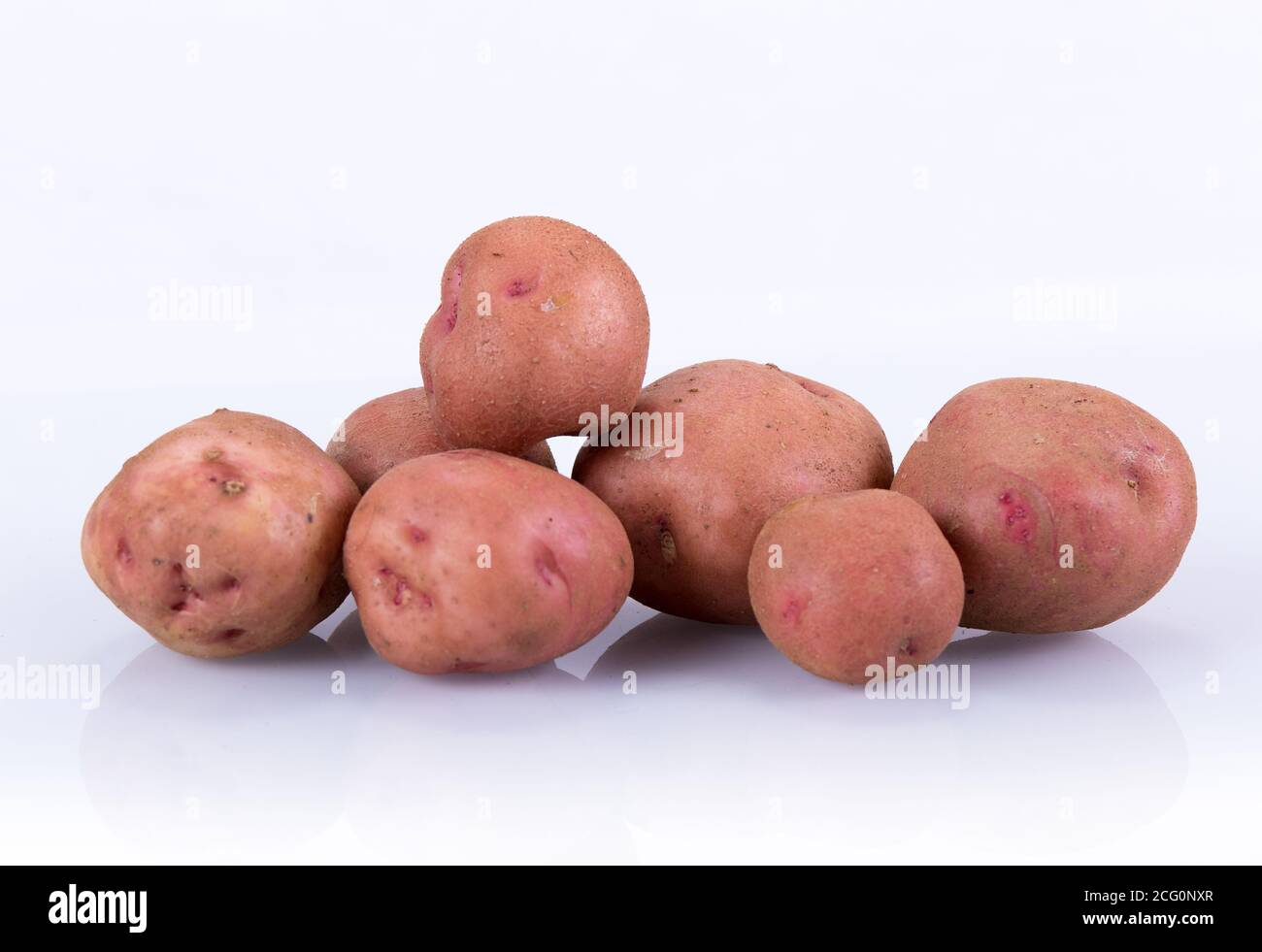 Patate in un mucchio isolato su fondo bianco con riflessione Foto Stock