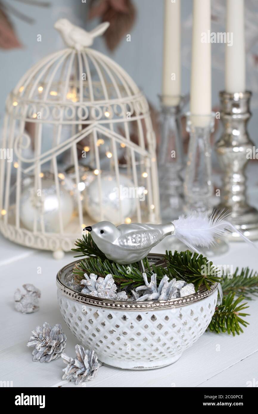 decorazione di natale in bianco e argento con uccello di vetro e. coni Foto Stock