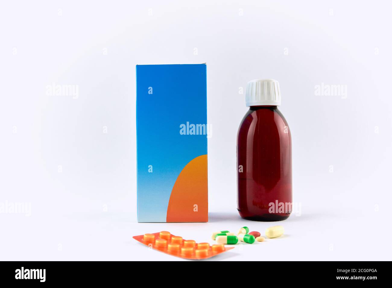 Flacone di sciroppo medicinale accanto a pillole e capsule Foto Stock