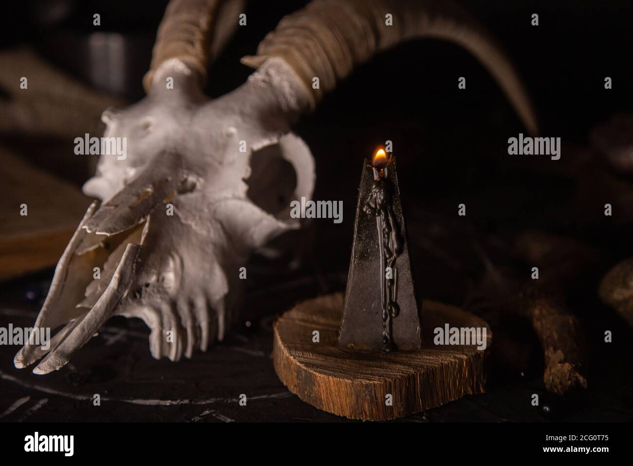 Gabbiano di capra bianco con corna, aprire il vecchio libro (testo - untraducibile, linguaggio immaginario), candele nere sul tavolo delle streghe. Occulto, esoterico, divinazione e. Foto Stock
