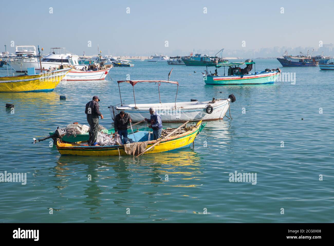 Alessandria, Egitto - 14 dicembre 2018: I pescatori riparano una rete in barca nel vecchio porto di pescatori di Alessandria Foto Stock