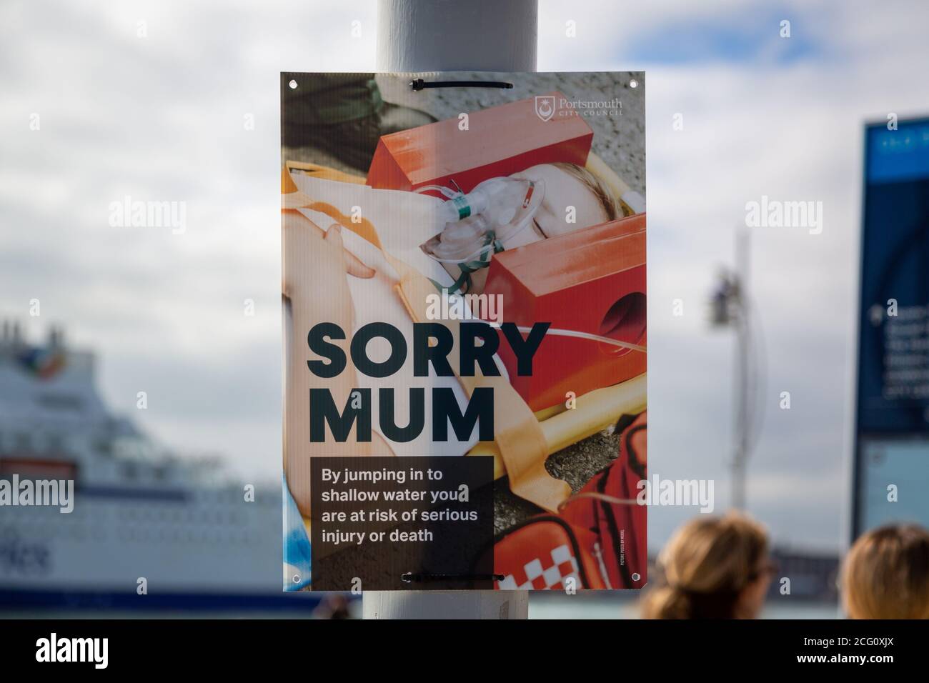 Un cartello in riva al mare che mostra un bambino ferito da saltare in acqua o tomblaoning con le parole spiacente la mamma ha scritto su di esso Foto Stock