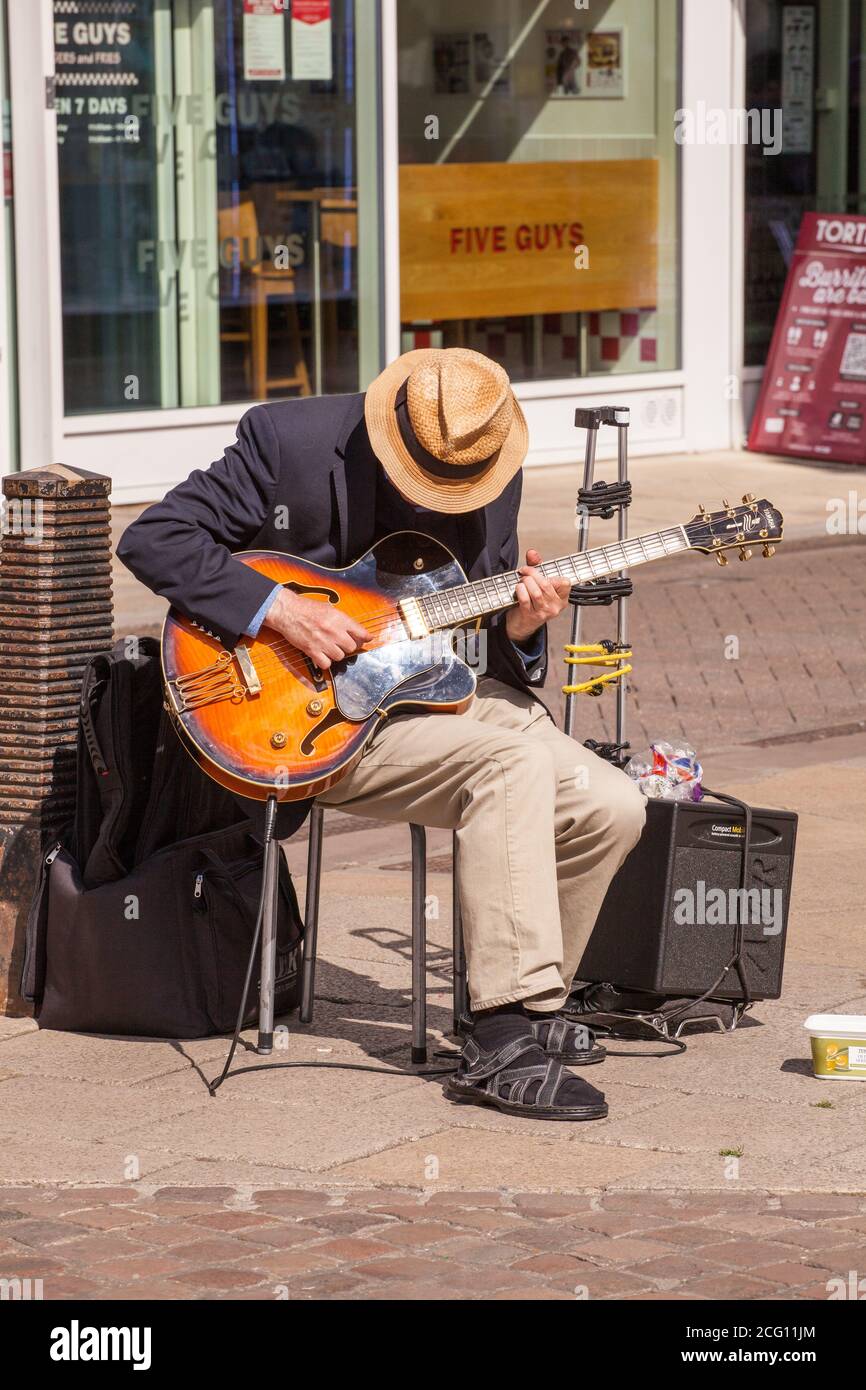 Busker Street performer che suona la chitarra in alta strada Della città Cambridgeshire di Cambridge Foto Stock