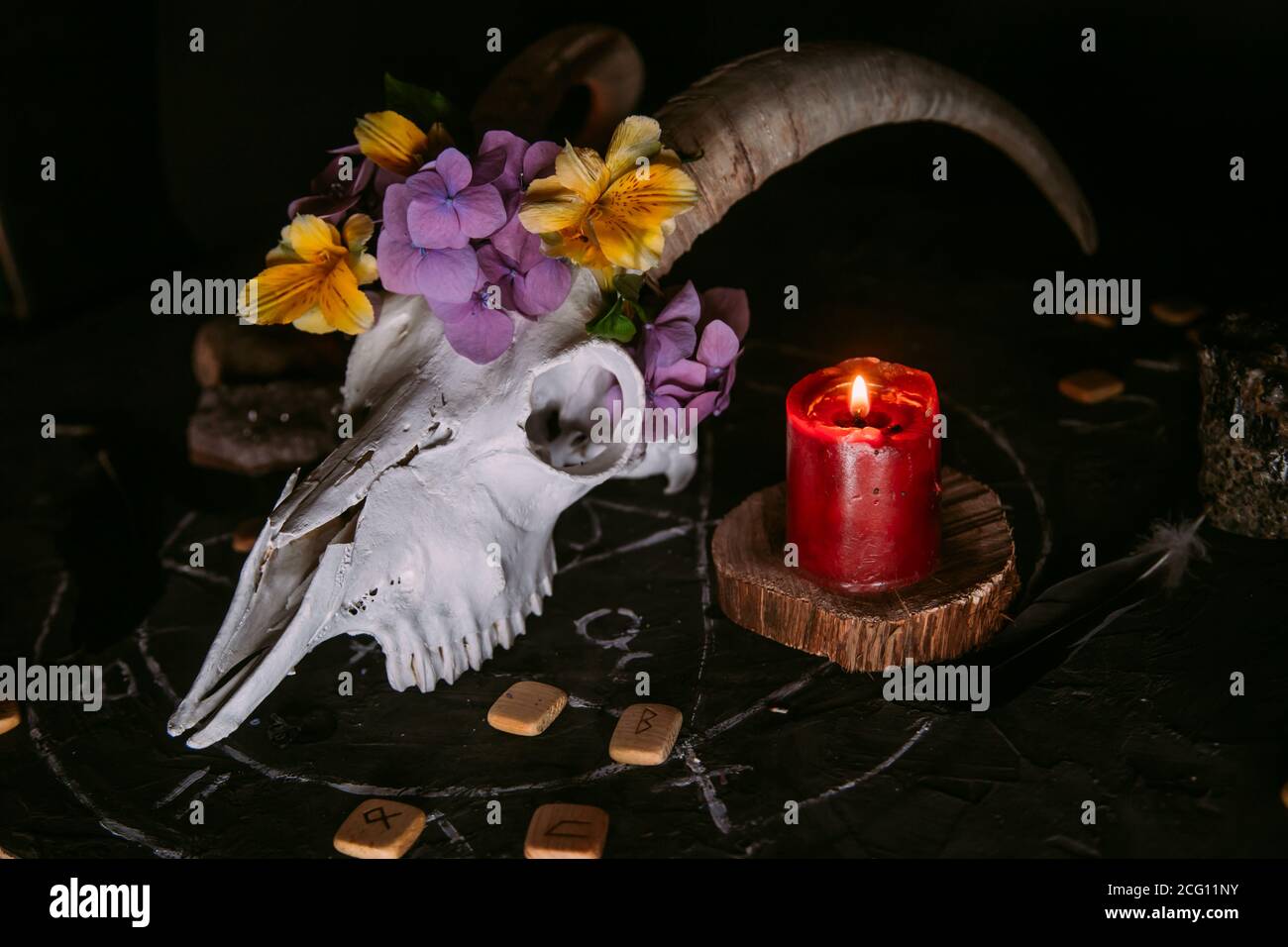 Gabbiano di capra bianco con corna, fiori, libro aperto vecchio, candele sul tavolo delle streghe. Concetto occulto, esoterico, divinazione e wicca. Halloween, giorno della dea Foto Stock