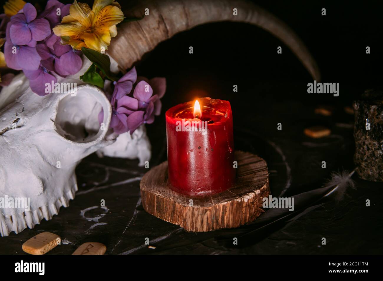 Gabbiano di capra bianco con corna, fiori, libro aperto vecchio, candele sul tavolo delle streghe. Concetto occulto, esoterico, divinazione e wicca. Halloween, giorno della dea Foto Stock
