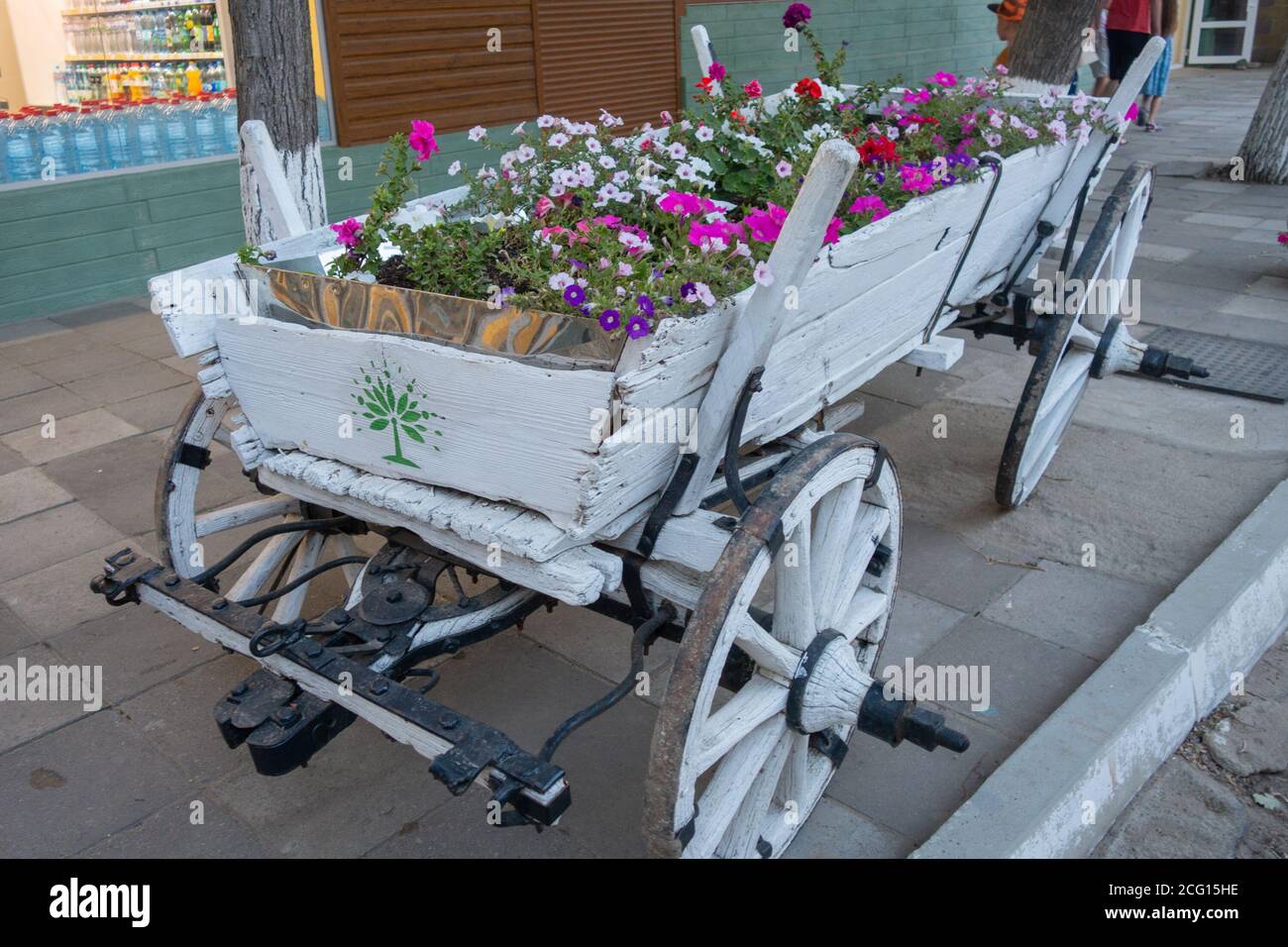 Un vecchio carro antico in bianco, pieno di fiori. Foto Stock