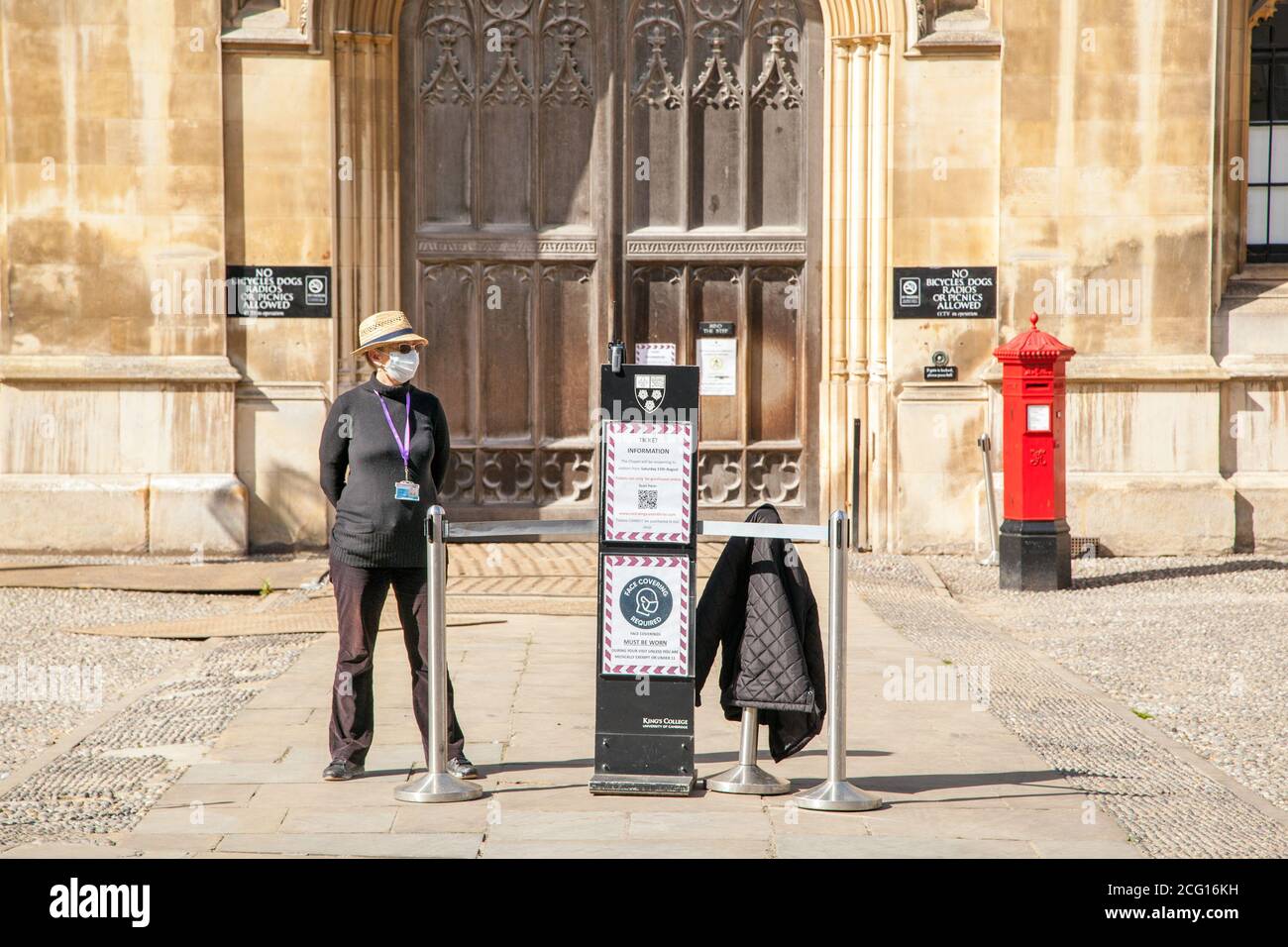 La guida del tour indossa una maschera che copre i re esterni Collage Cambridge in attesa di clienti durante la pandemia di covid 2020 Foto Stock