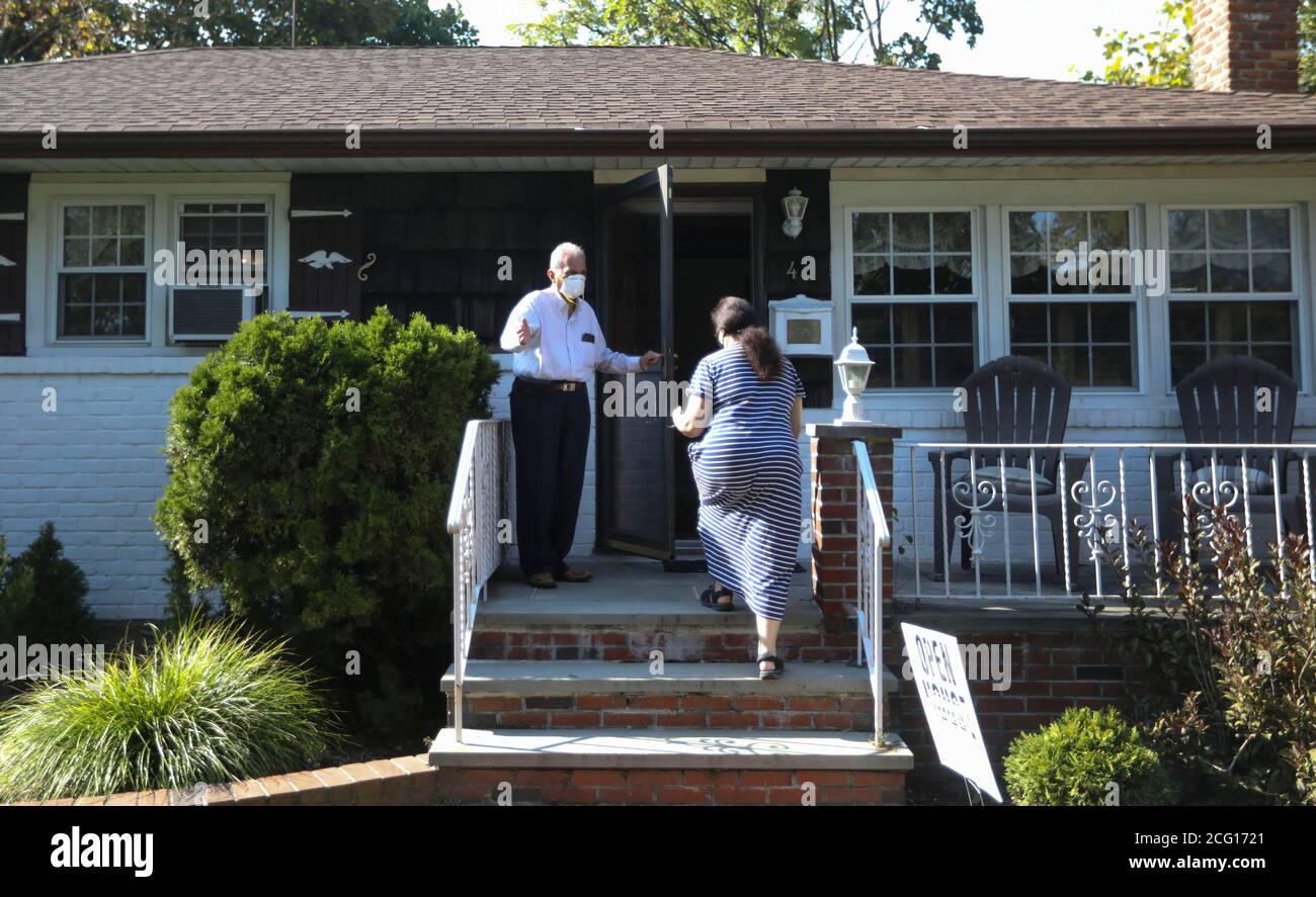 New York, Stati Uniti. 6 Settembre 2020. Hemant Shah (L), un broker con Laffey Real Estate a Long Island, accoglie un potenziale acquirente al di fuori di una casa in vendita a New Hyde Park, Nassau County, New York, Stati Uniti, il 6 settembre 2020. I compratori domestici che mangiano per i backyards intimi e più spazio dell'ufficio stanno organizzando le guerre d'offerta nei sobborghi che circondano New York City in mezzo alla diffusione della pandemia di COVID-19. Credit: Wang Ying/Xinhua/Alamy Live News Foto Stock