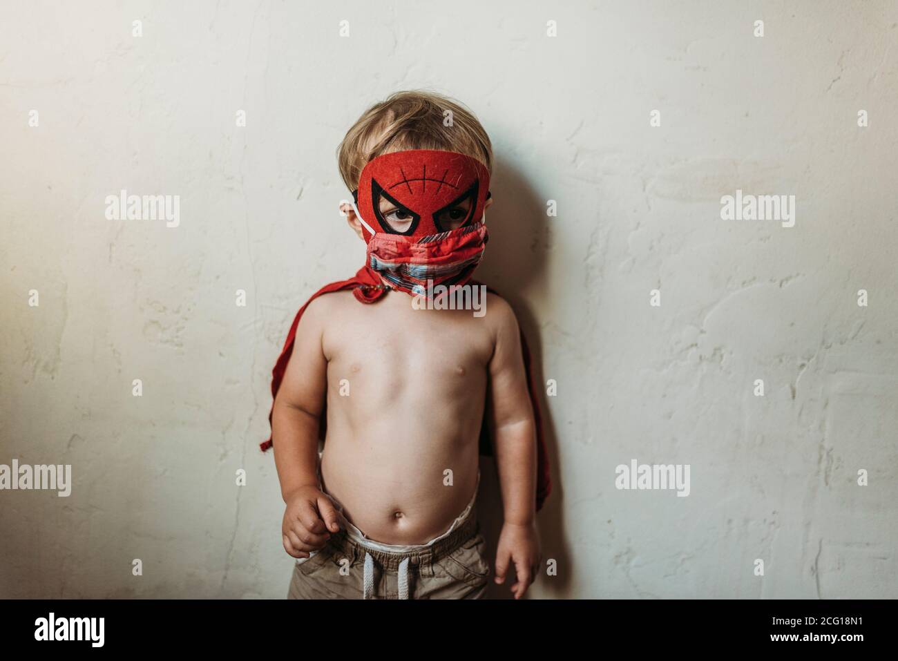 Bambino ragazzo in piedi in costume di Halloween e maschera facciale Foto Stock
