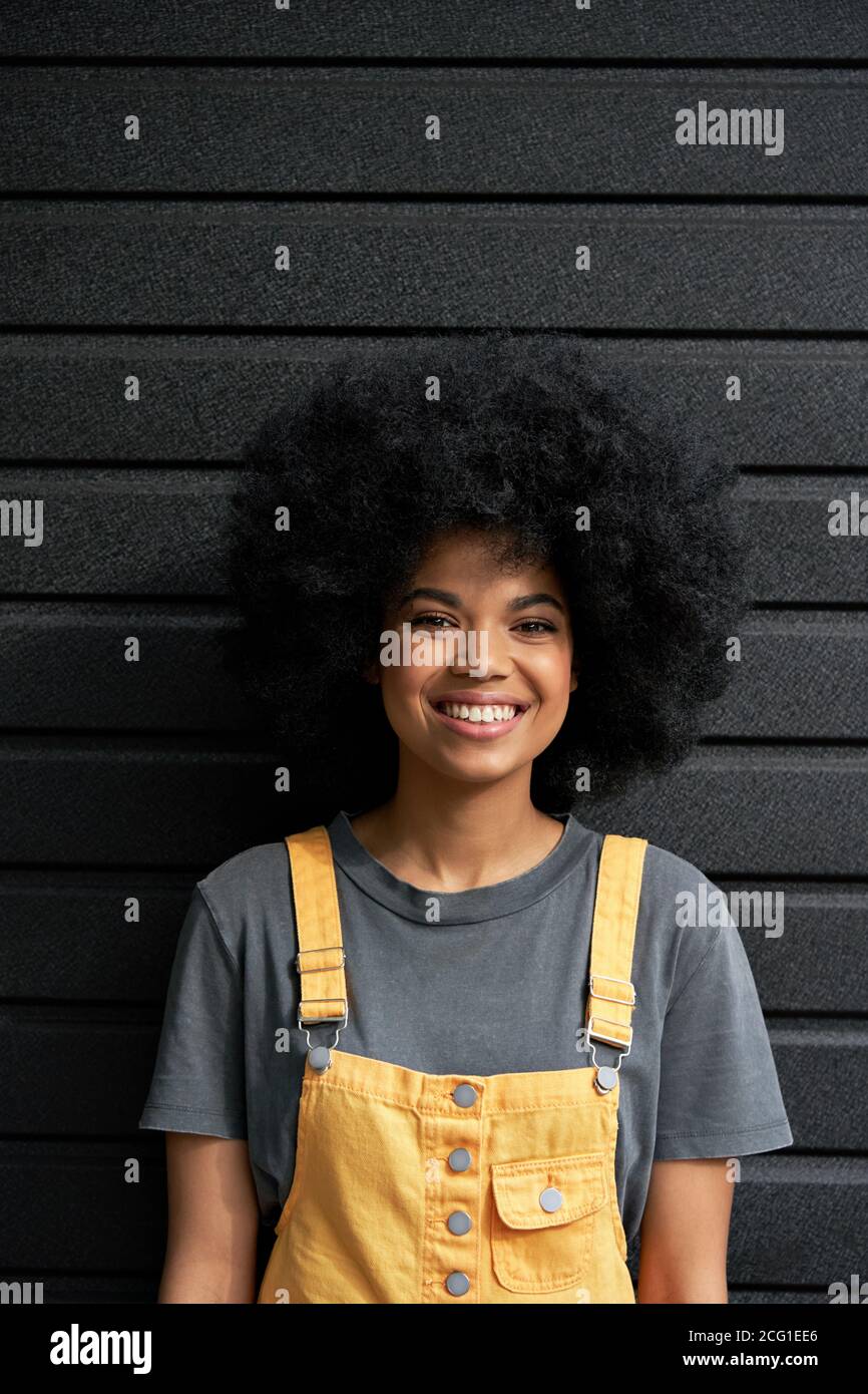 Donna hipster africana felice con i capelli afro guardando la macchina fotografica, verticale ritratto. Foto Stock