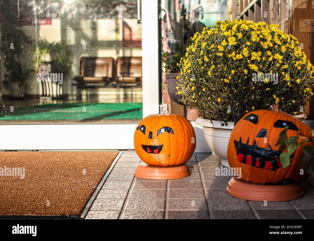 Due zucche di Halloween con facce all'ingresso di a. affari Foto Stock