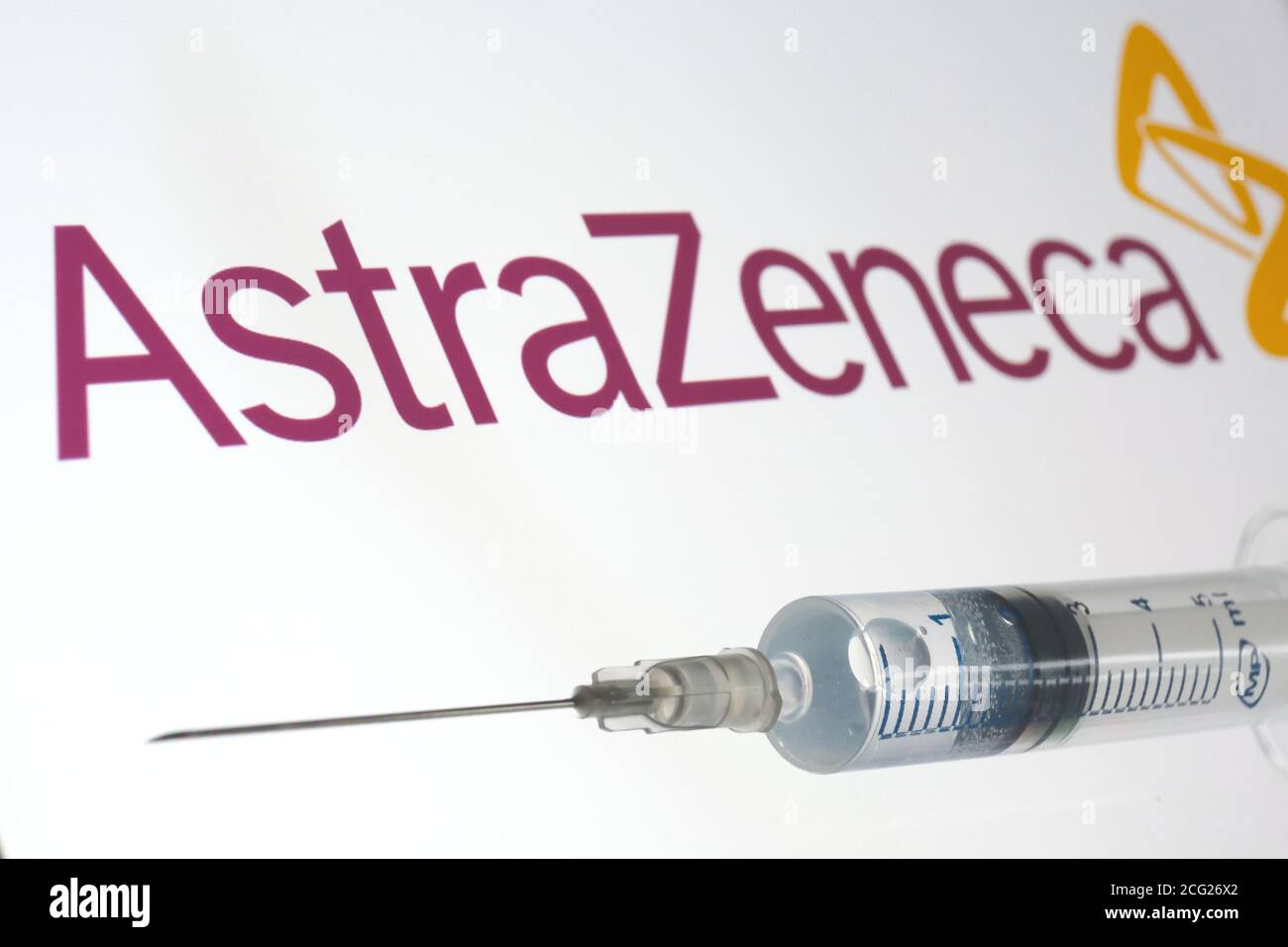 AstraZeneca Oxford vaccino concetto. Siringa su schermo bianco e logo AstraZeneca su sfondo sfocato. Foto Stock