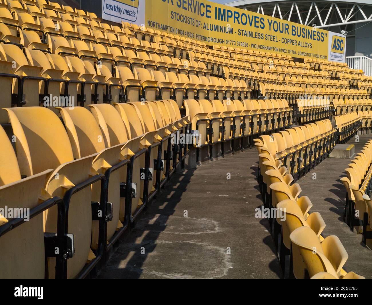 File di posti vuoti gialli presso il County Ground, sede del Northamptonshire, County Cricket Club, Regno Unito Foto Stock