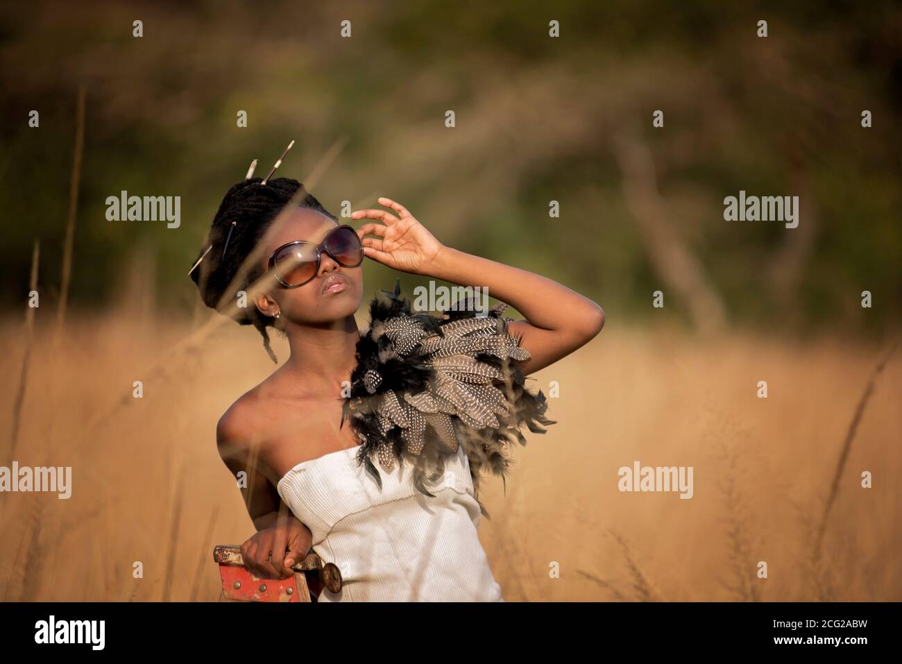 modello donna nera di successo in safari africano con occhiali da sole Foto Stock