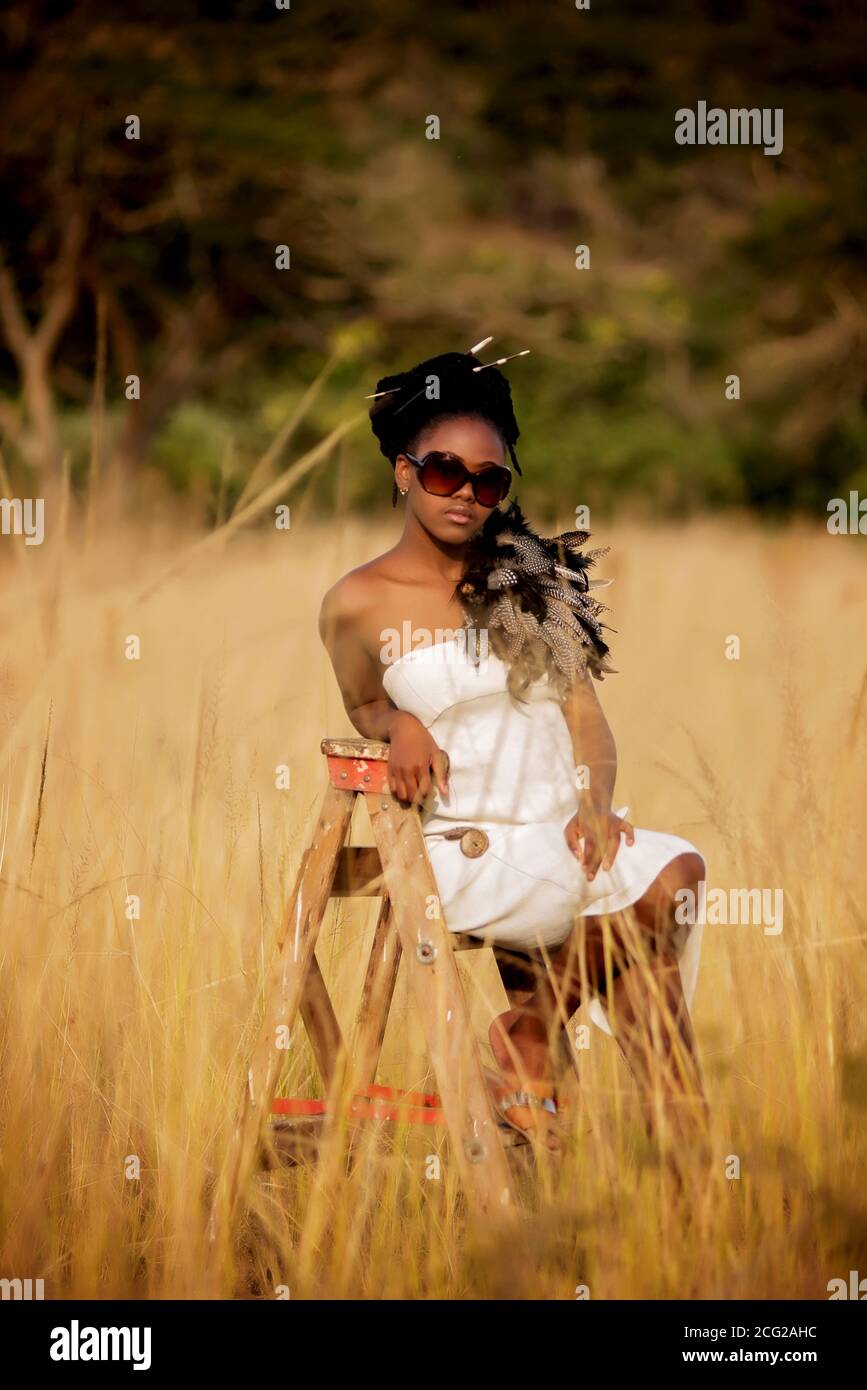modello donna nera di successo in safari africano con occhiali da sole Foto Stock