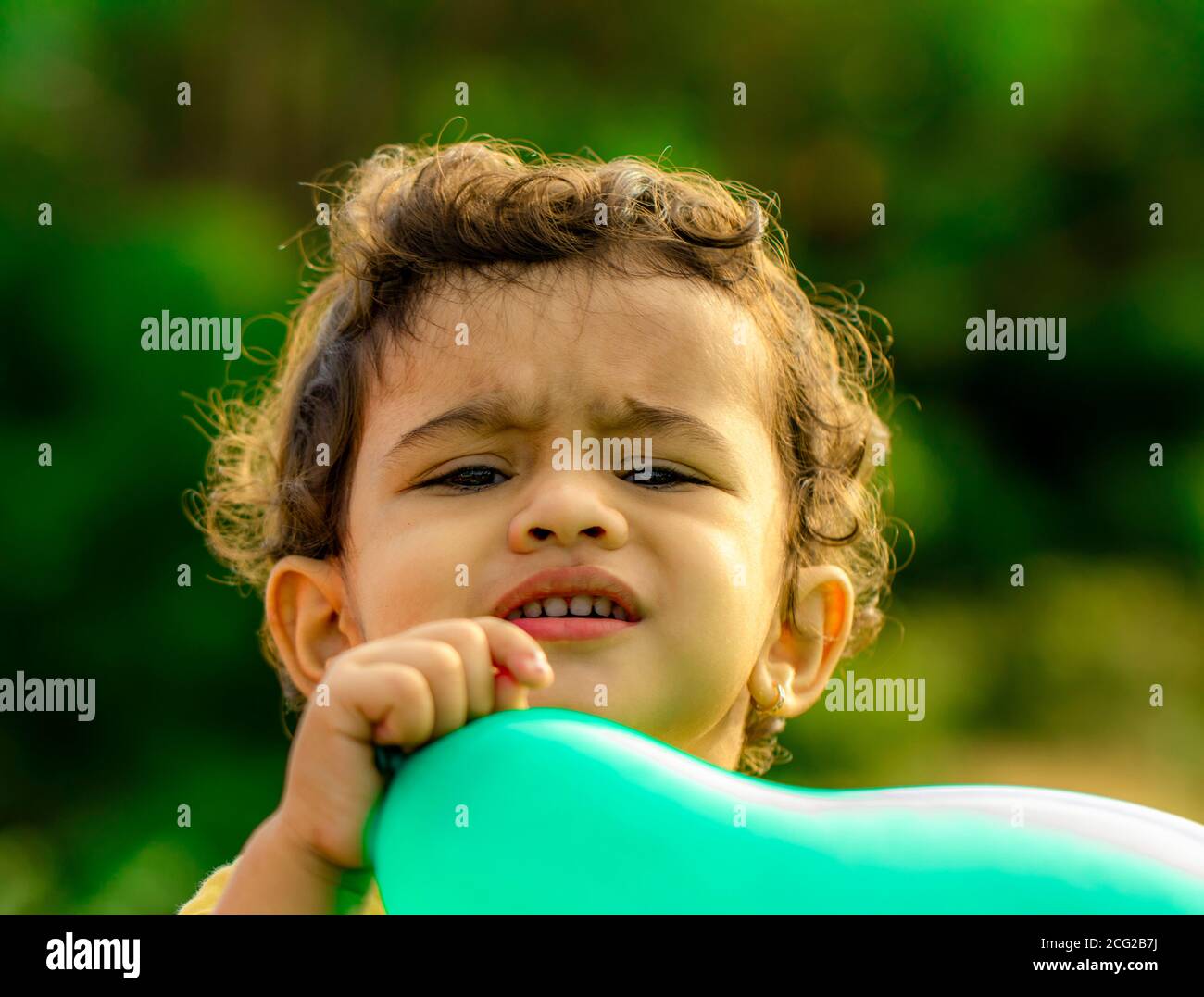 Vista ravvicinata del viso di un bambino piccolo e tenendo un palloncino blu Foto Stock
