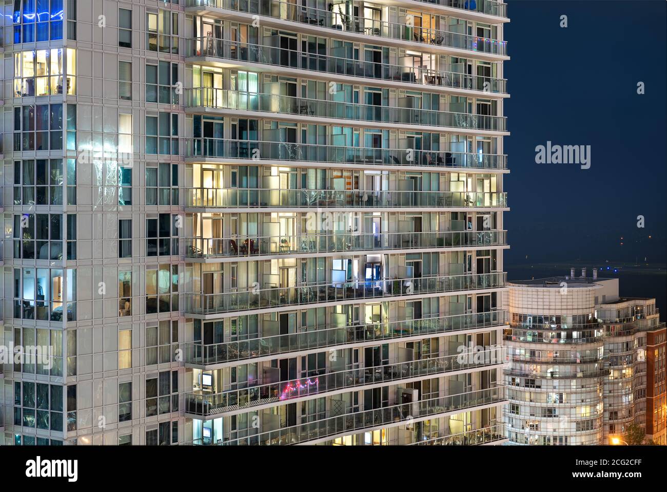 la luce brucia in una finestra della moltitudine in un edificio residenziale a più piani Foto Stock