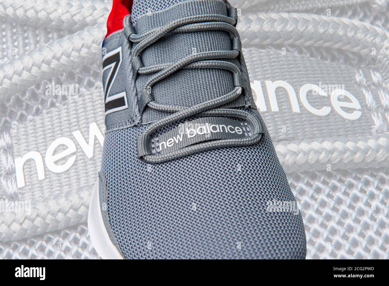 Sneaker Grey e Red New Balance girate in uno studio Foto Stock