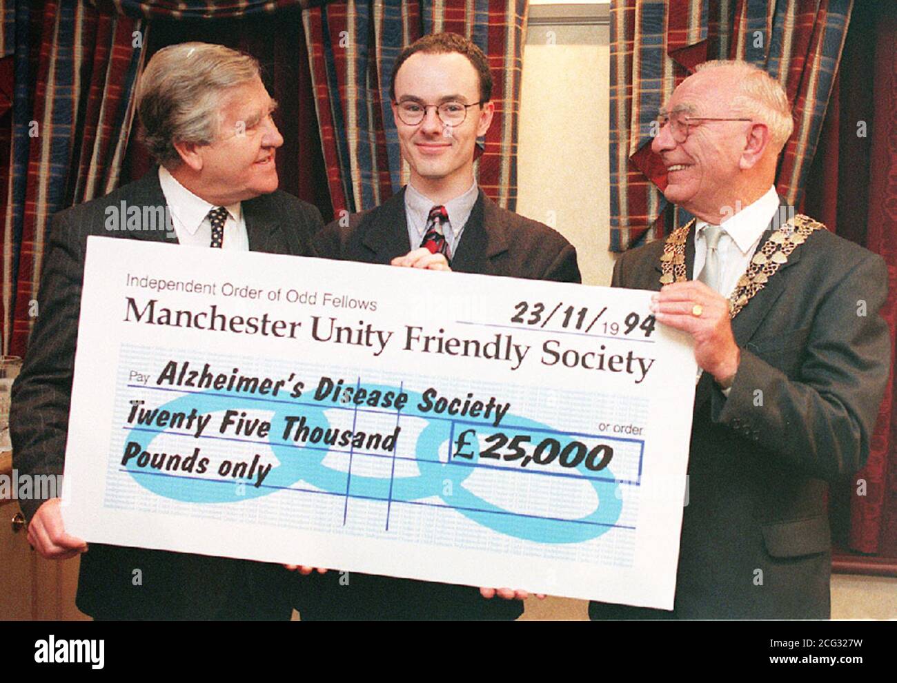 PAP 19: LONDRA: 23.11.94: John Goulding (destra), presidente del consiglio di amministrazione della Manchester Unity friendly Society, presenta un assegno per il 25,000 al dottor Declan McLoughlin (centro), che sta conducendo un programma di ricerca del Regno Unito sulle cause del morbo di Alzheimer e sulle possibili misure preventive, E Alf Morris MP, vice presidente della Alzheimer's Disease Society, a Londra oggi (mercoledì). La donazione sarà utilizzata per studiare il comportamento della proteina amiloide, generalmente accettata come la causa principale della malattia. Vedere PA storia SALUTE Alzheimer. PA NEWS, TONY HARRIS/GM. Foto Stock