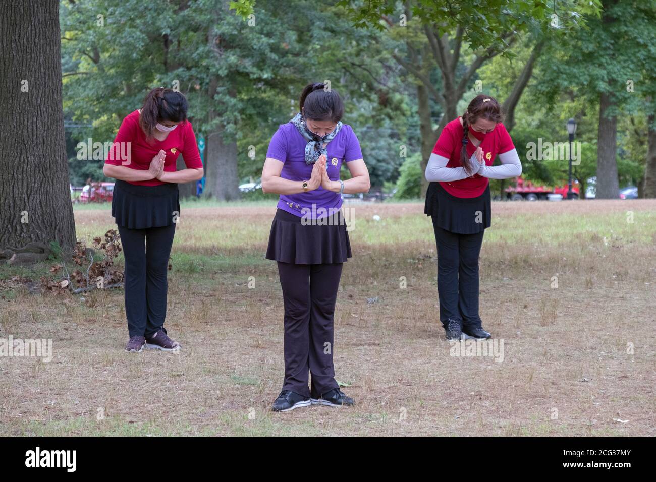 3 donne asiatiche americane di mezza età che indossano maschere chirurgiche frequentano una lezione di Tai Chi a Kissena Park, Flushing, Queens, New York City. Foto Stock