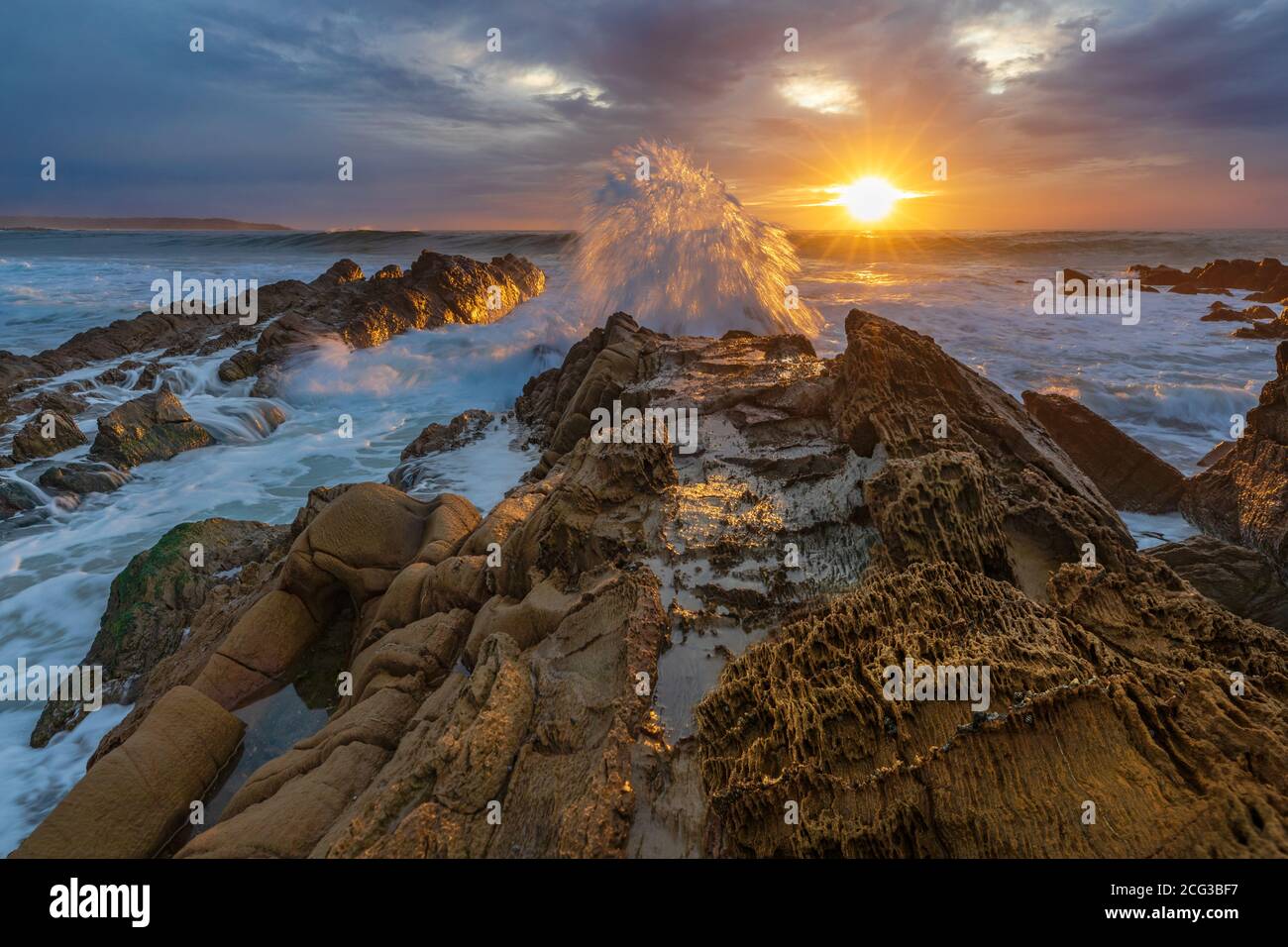 Onde e luce - onde sulle rocce all'alba a Cuttagee NSW, Australia. Foto Stock