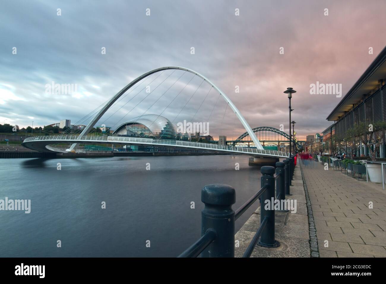 Il Gateshead Millennium Bridge che attraversa il fiume Tyne catturato al crepuscolo dalla banchina di Newcastle guardando il fiume Tyne. Foto Stock