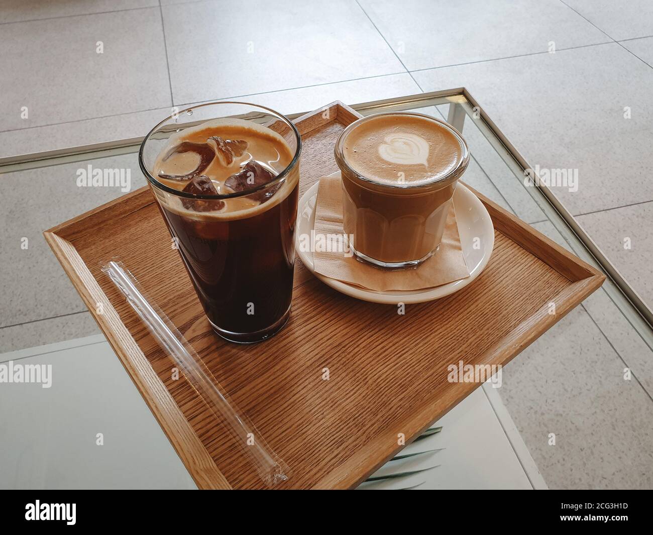 ghiacciato americano e caffè caldo latte. Americano viene preparato diluendo un espresso con acqua calda. Il caffè latte viene preparato con caffè espresso e latte al vapore. Foto Stock