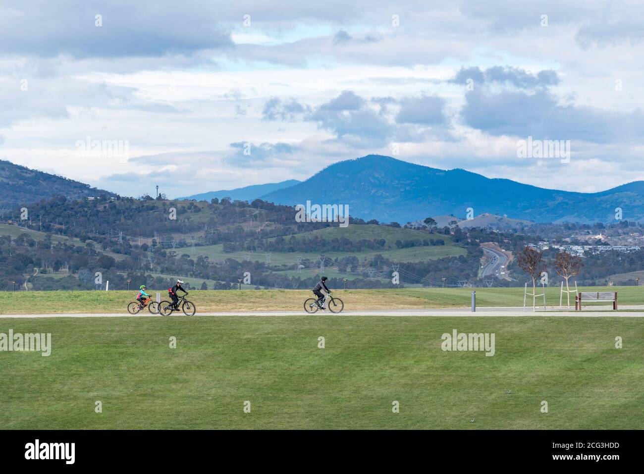I motociclisti in mountain bike passano lungo uno dei numerosi sentieri che attraversano l'Arboreto Nazionale di Canberra, Australian Capital Territory, Australia Foto Stock