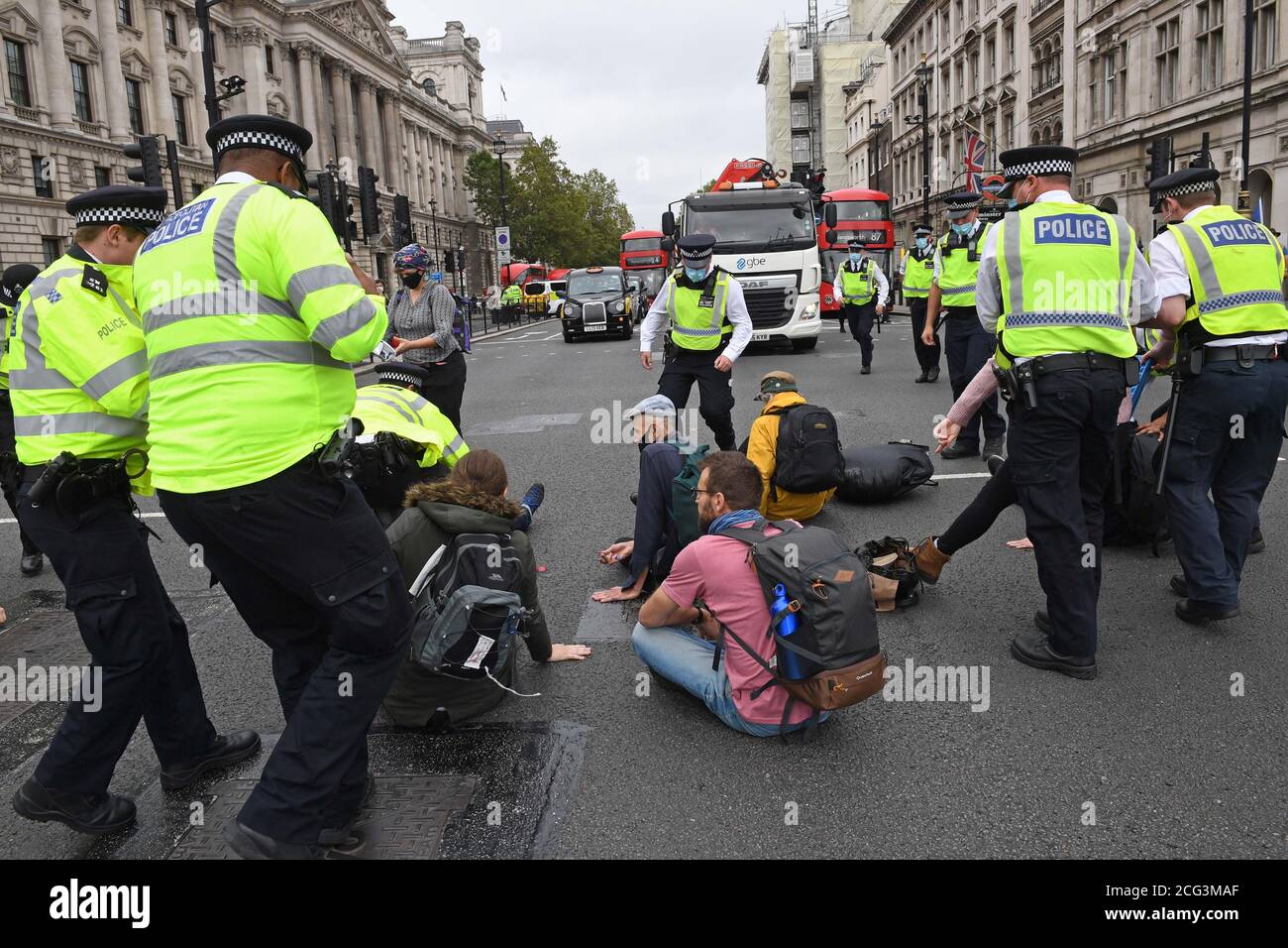 I poliziotti rimuovono i manifestanti che si sono seduti in strada presso Piazza del Parlamento durante una protesta di rivolta dell'estinzione (XR) a Londra. Foto Stock